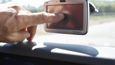 Man touching GPS display in car